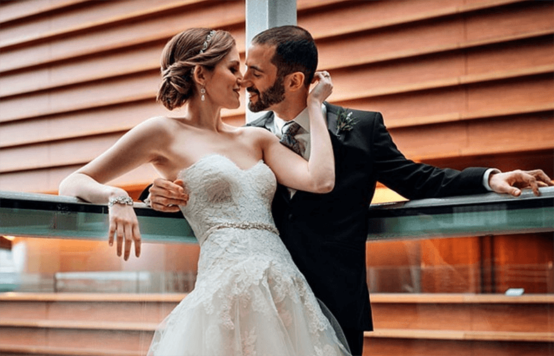 A bride and groom share an intimate moment while standing along one of the Kimmel Center's balconies.