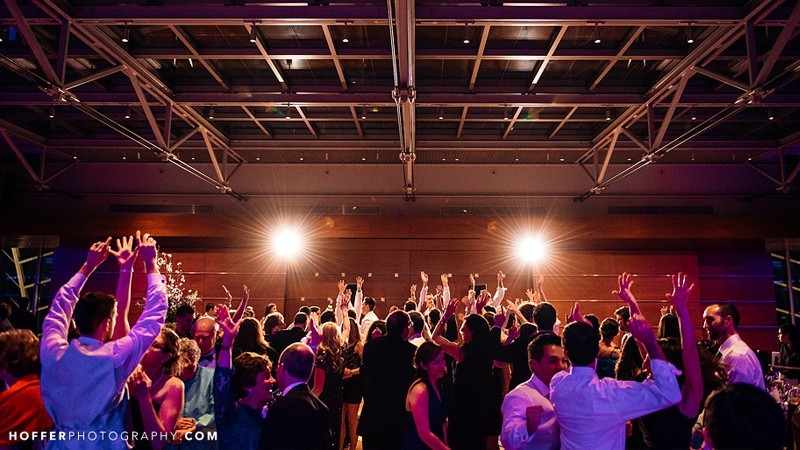 Wedding guests dance and cheer at a reception held in the Hamilton Garden Ballroom.