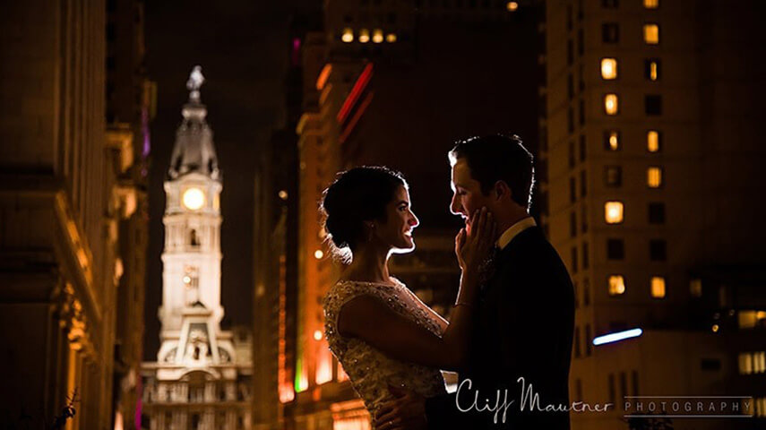 A groom and bride standing on the terrace at night.