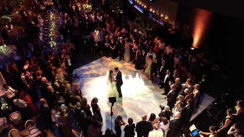 A bride and groom has their first dance at the center of the Commonwealth Plaza.
